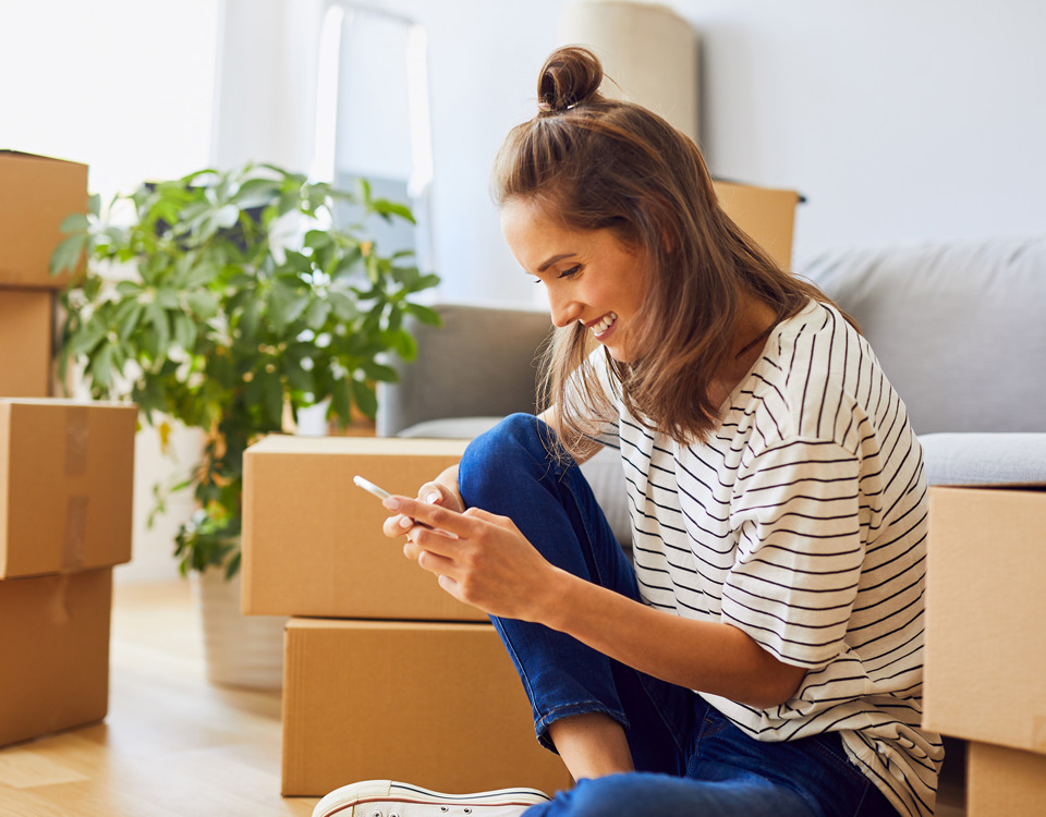 Smilende kvinde som kigger på sin telefon