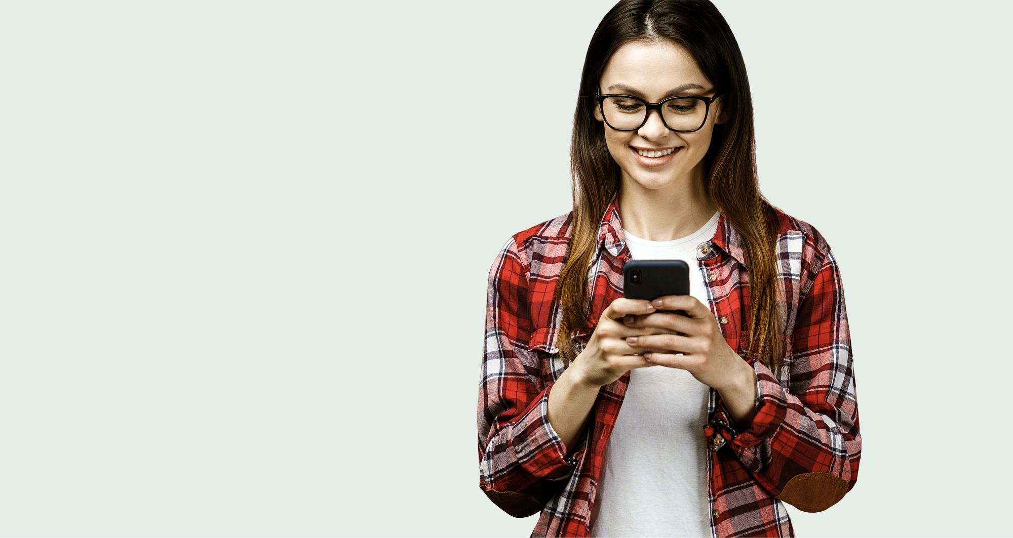 Smilende kvinde som kigger på sin smartphone