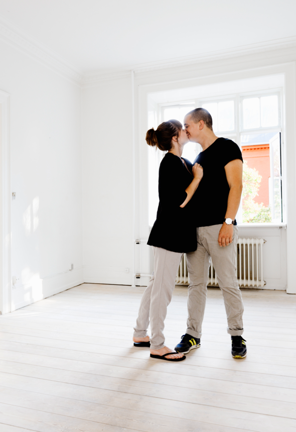 Mand og dame der kysser i en stue